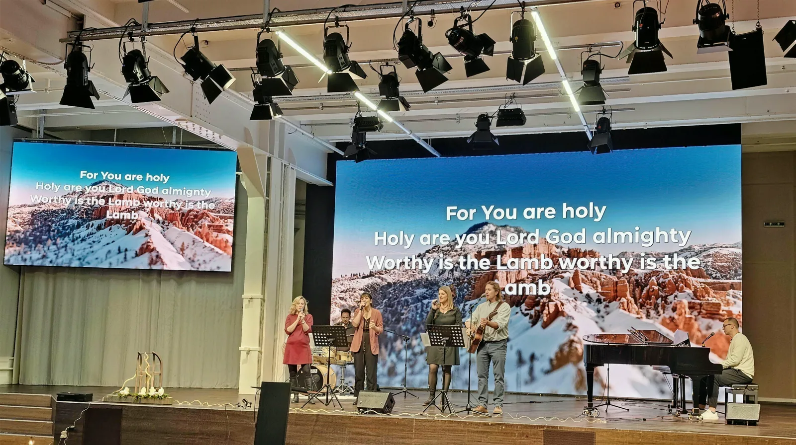 Anbetung im Christlichen Zentrum Bern: die Band singt auf der Bühne vor der grossen LED-Wand, am Flügel wird begleitet