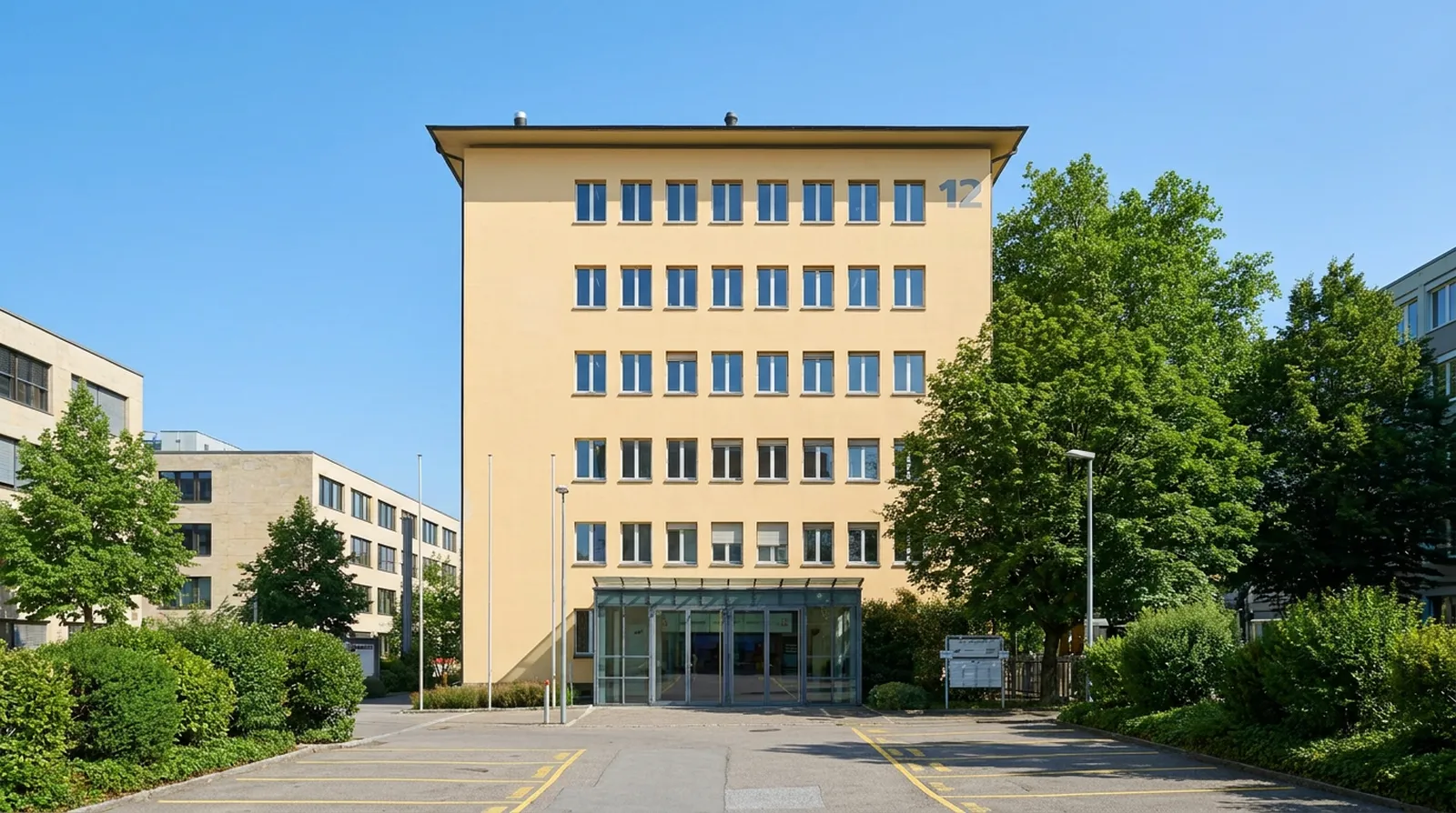 Das Gebäude an der Fabrikstrasse 12 in Bern mit der grossen 12 an der Fassade und dem Glaseingang — das Christliche Zentrum Bern ist im Erdgeschoss